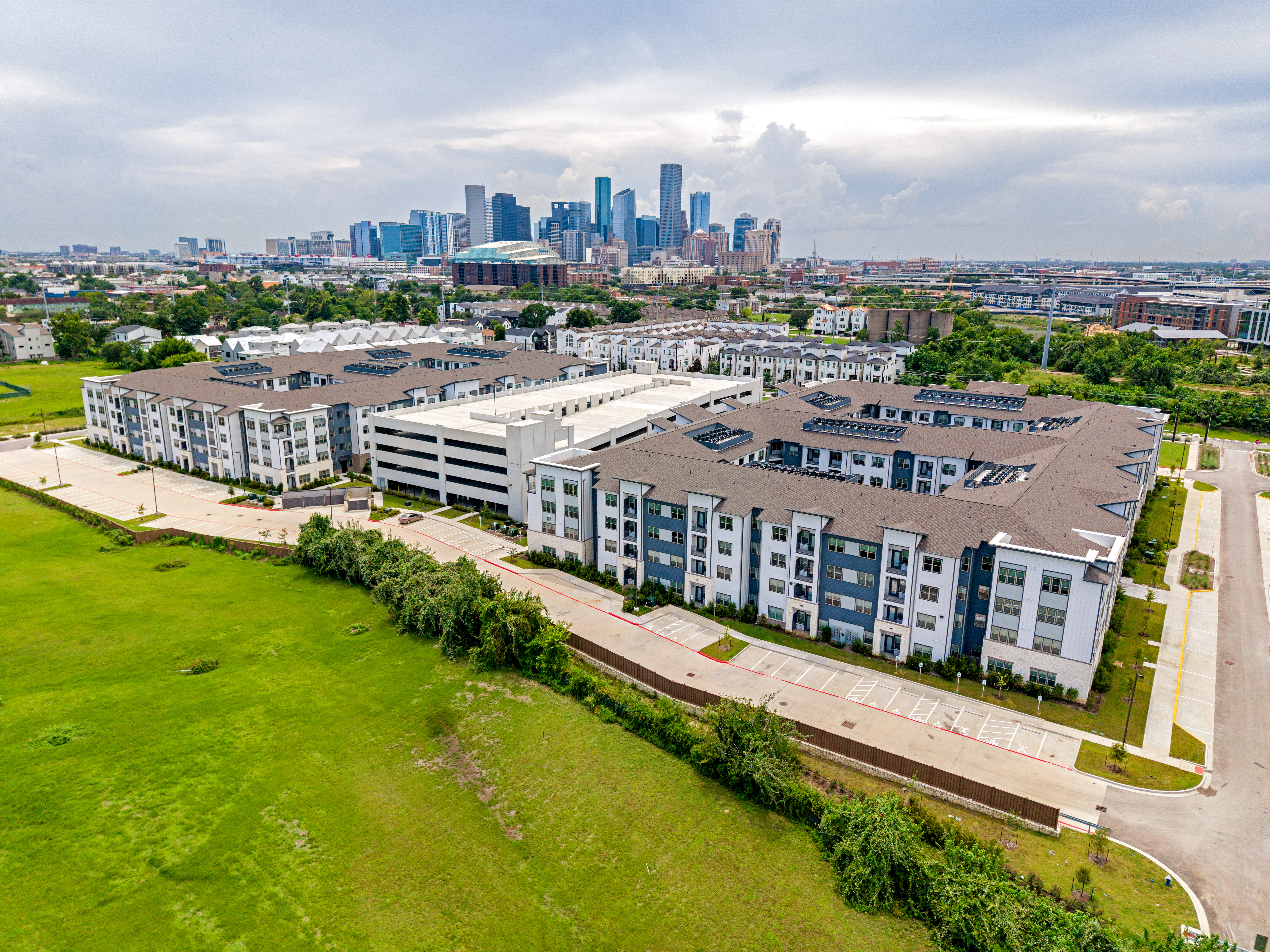 Aerial photograph of a Houston apartment complex with downtown skyline