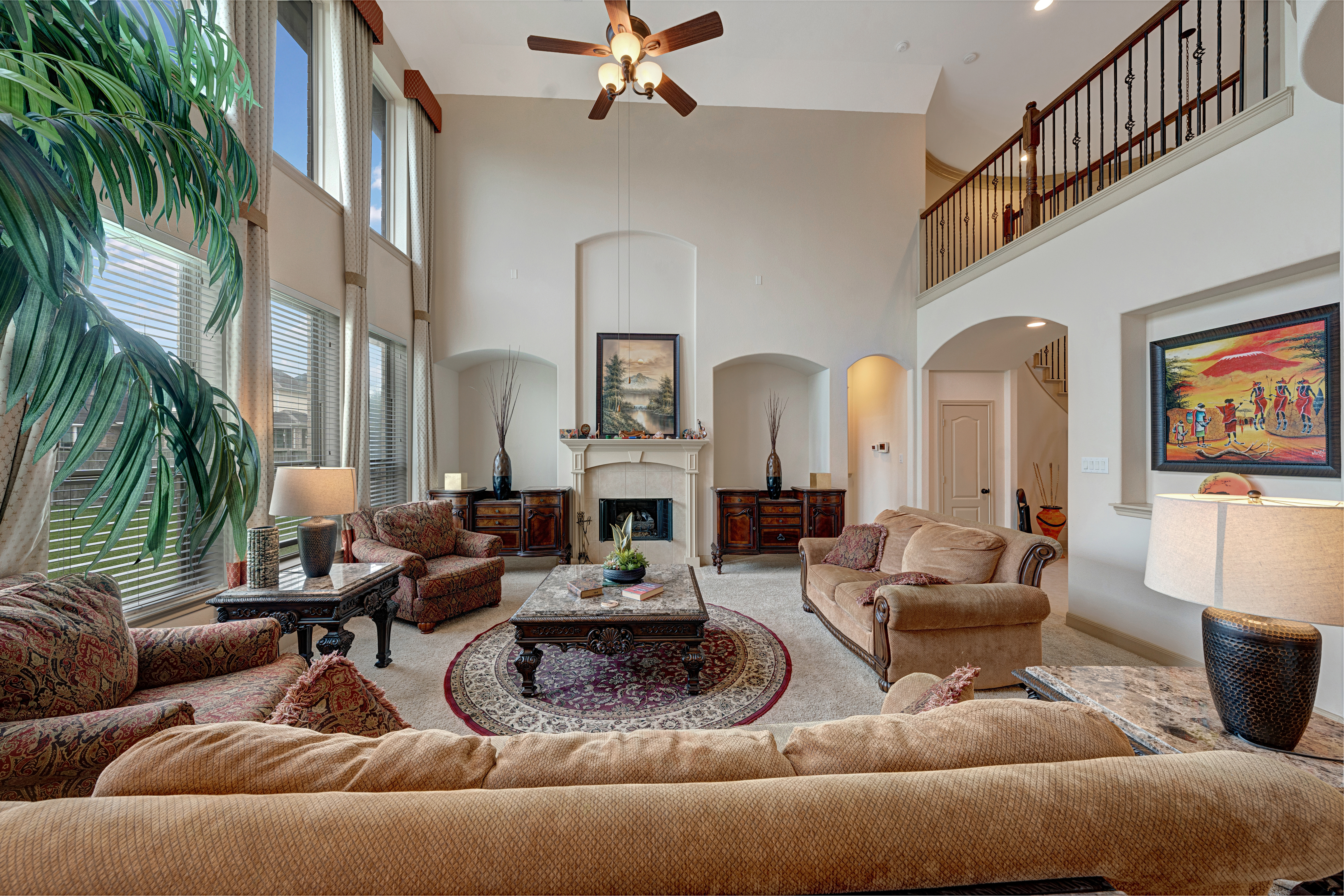 Two-story living room with fireplace and tall windows