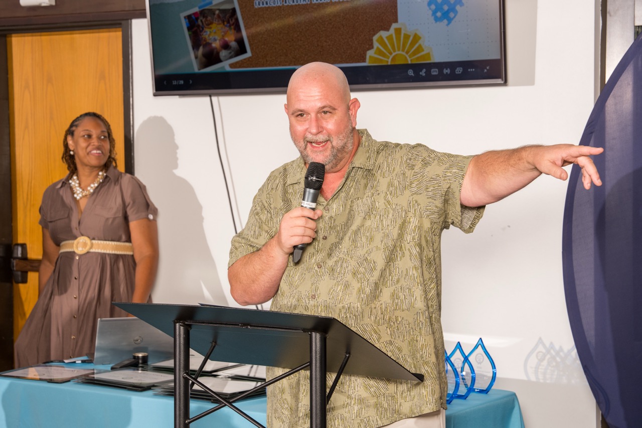 Speaker gesturing while addressing guests at a corporate event