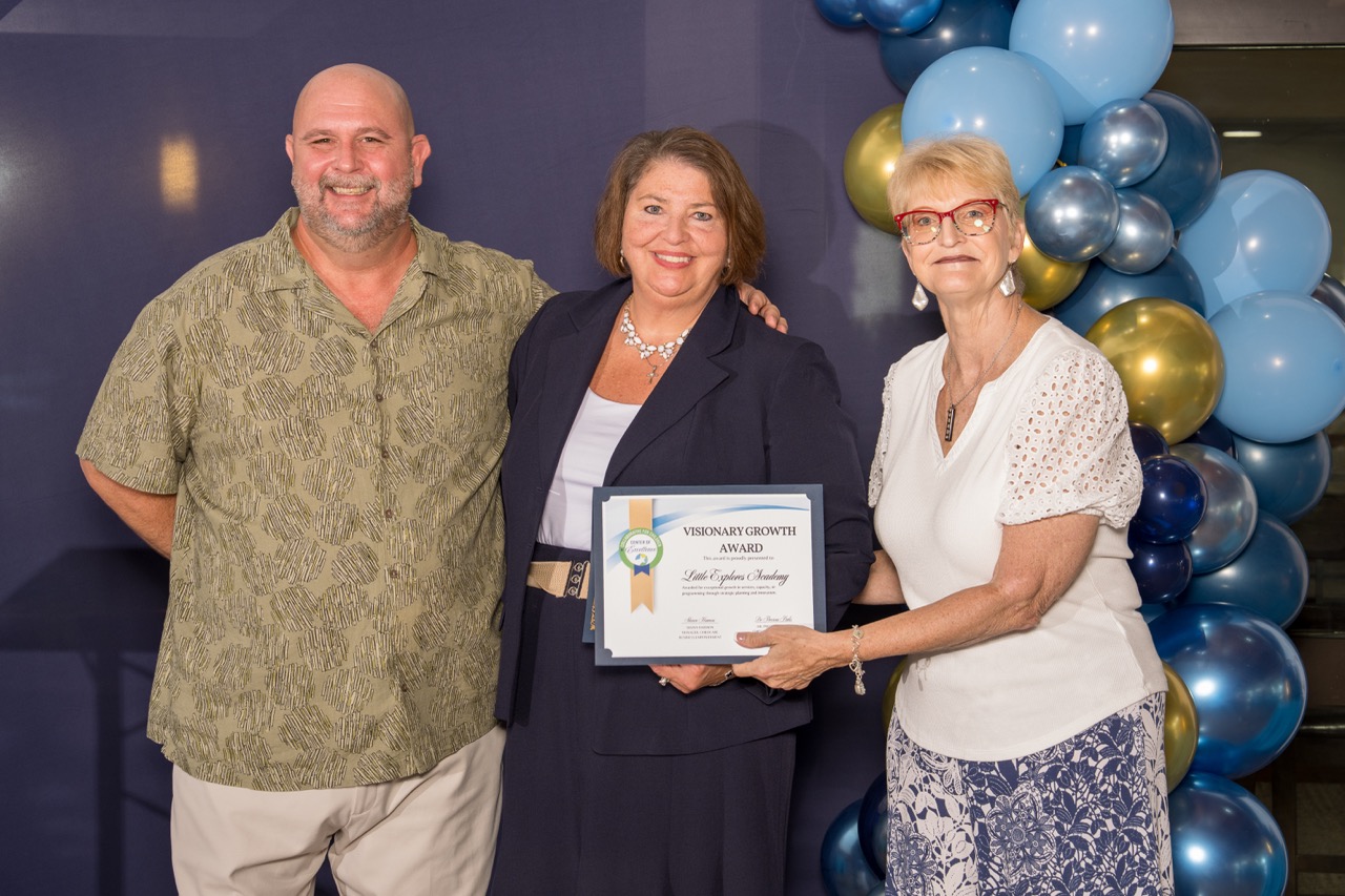Group posing with a Visionary Growth Award at a corporate gala