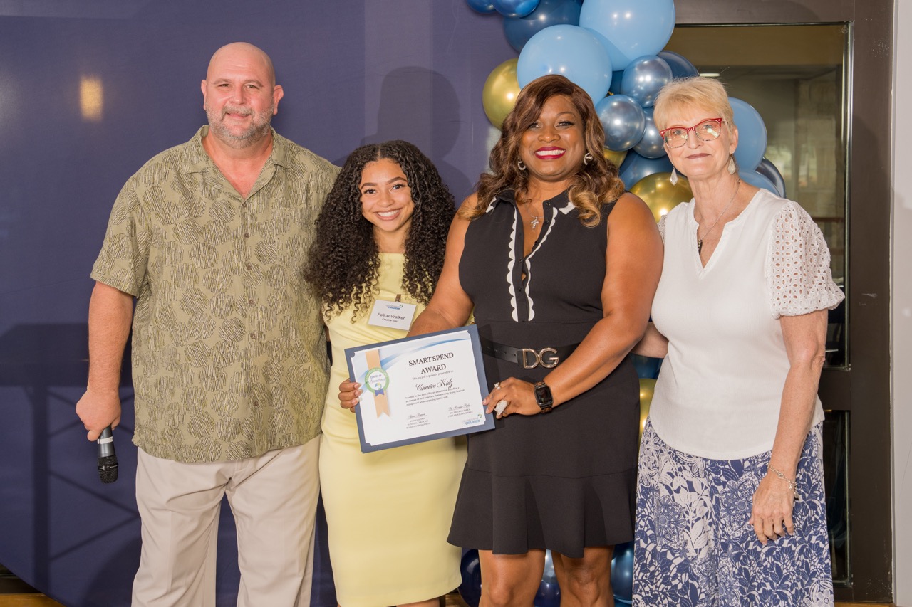 Group posing with a Smart Spend Award at a corporate gala