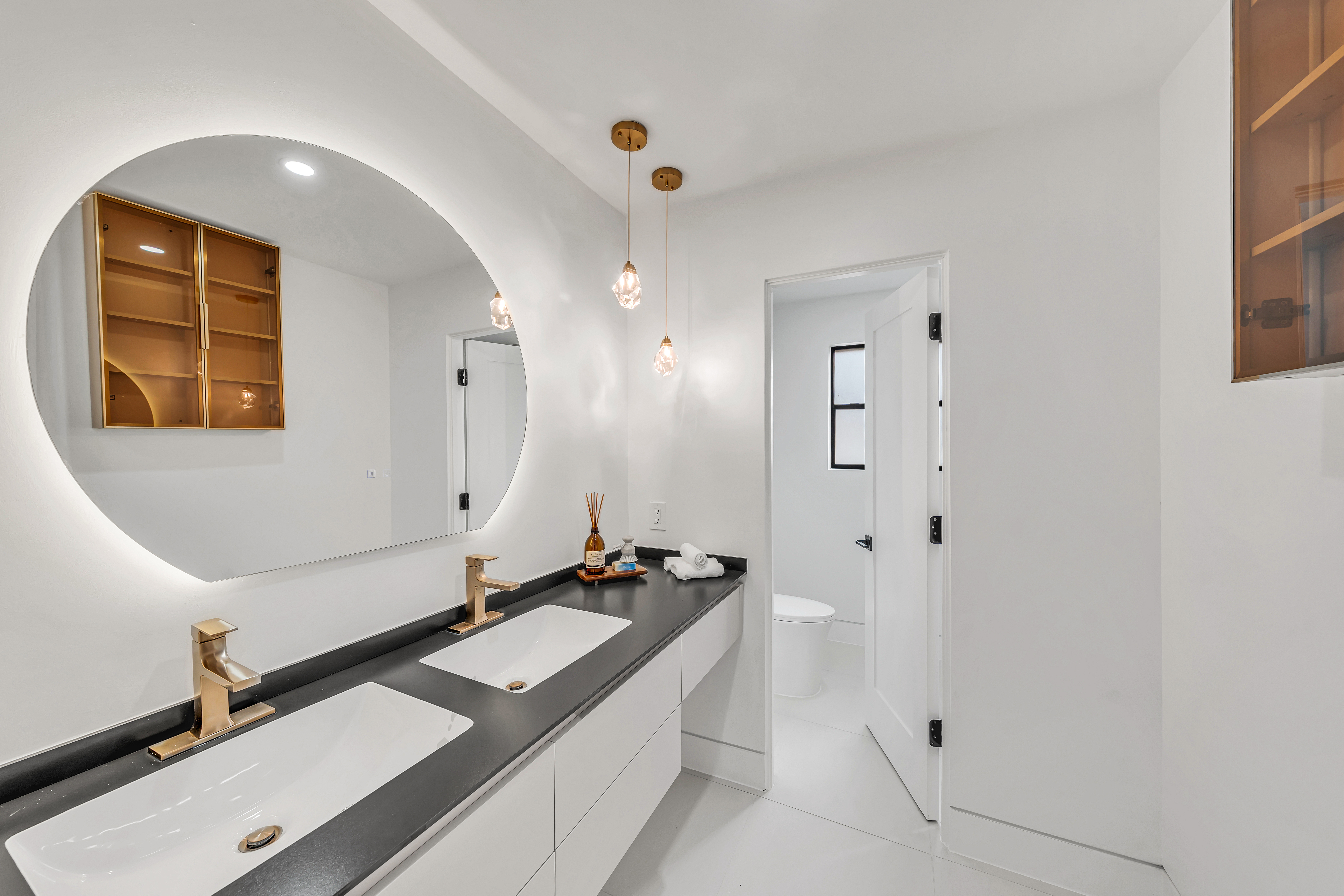 Modern bathroom with round backlit mirror