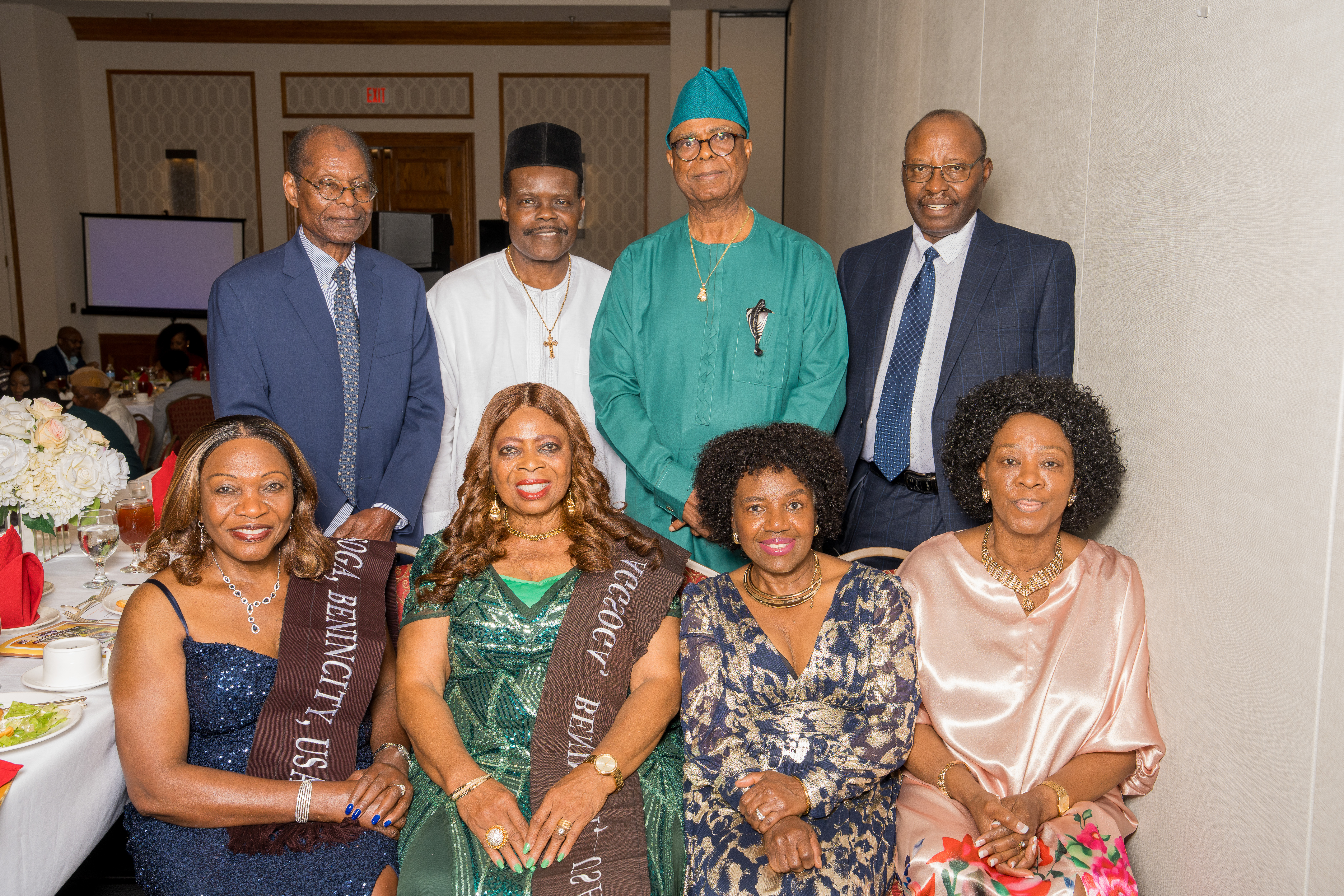 Group of guests posing at a dinner table during a gala