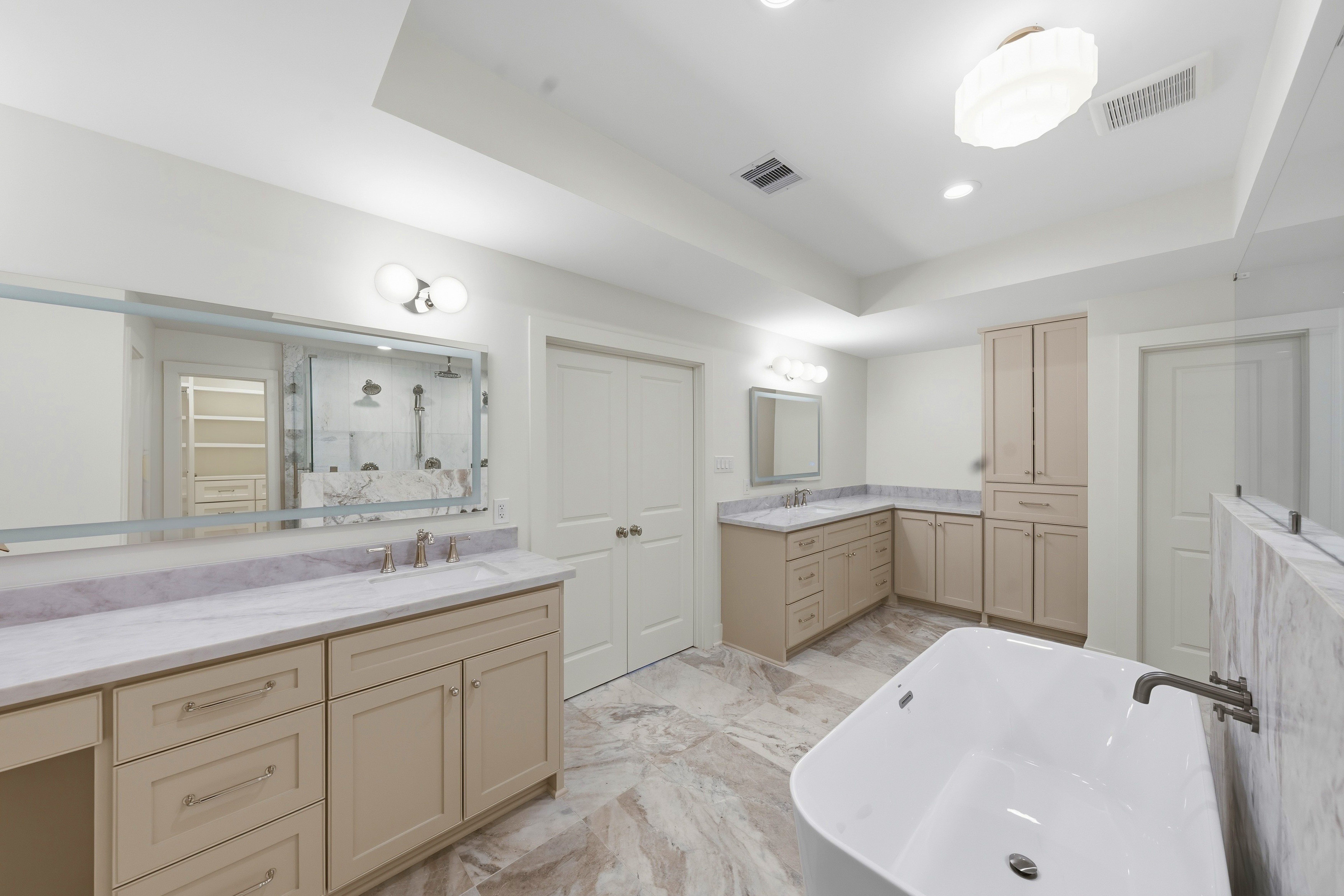 Primary bathroom with dual vanities and soaking tub
