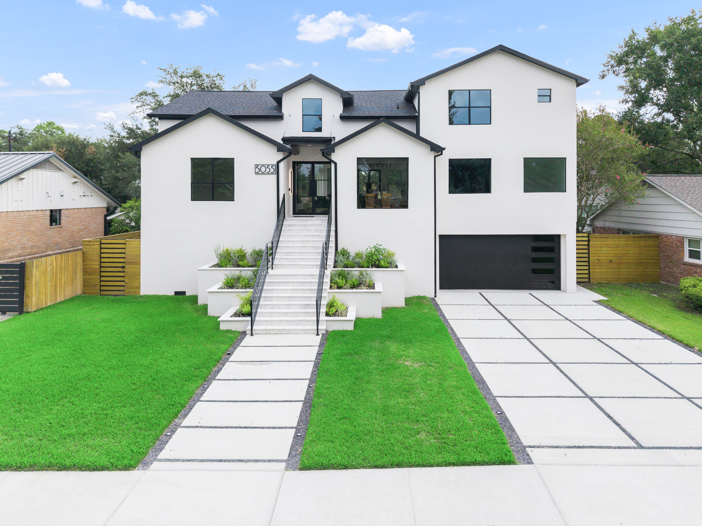 Aerial view of a white stucco home with three-car garage