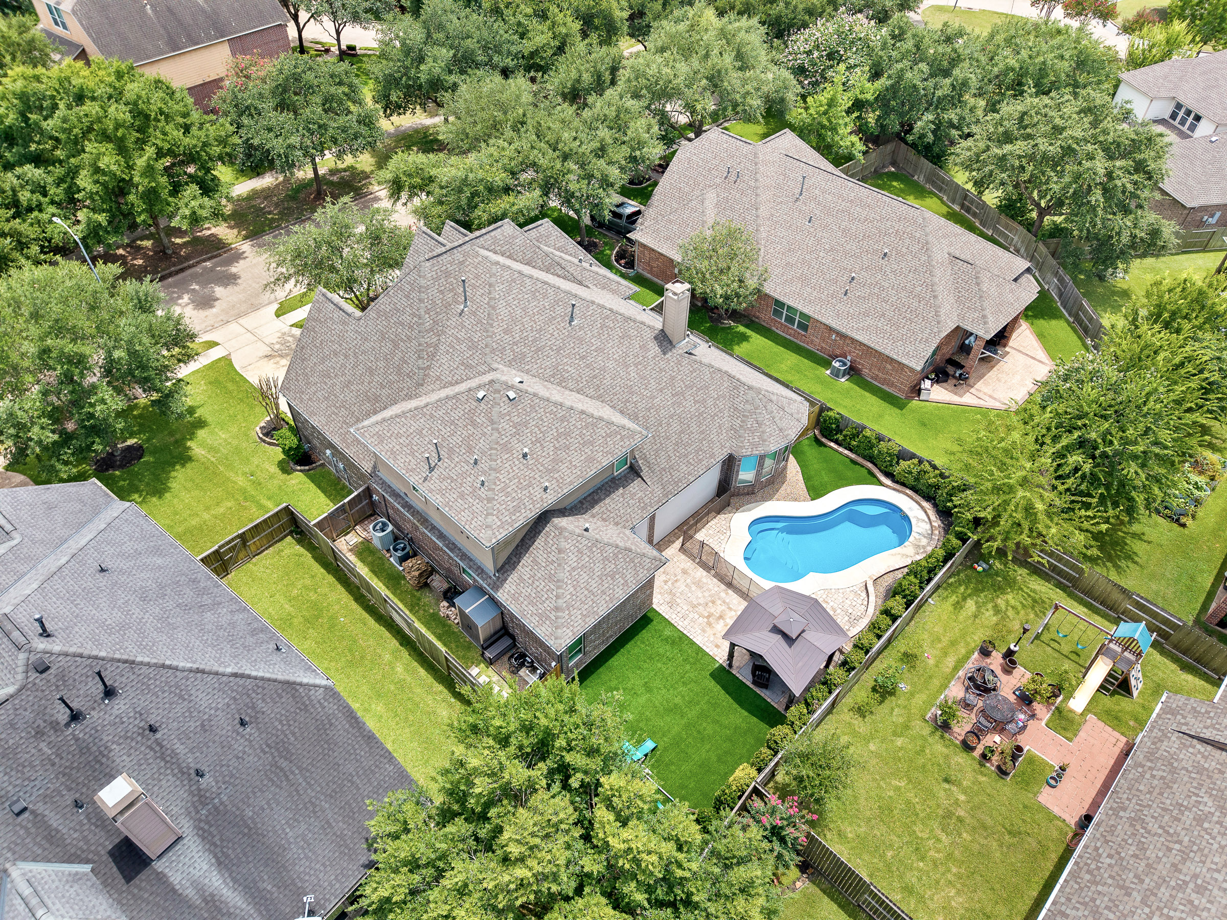 Aerial view of a home with backyard pool and gazebo