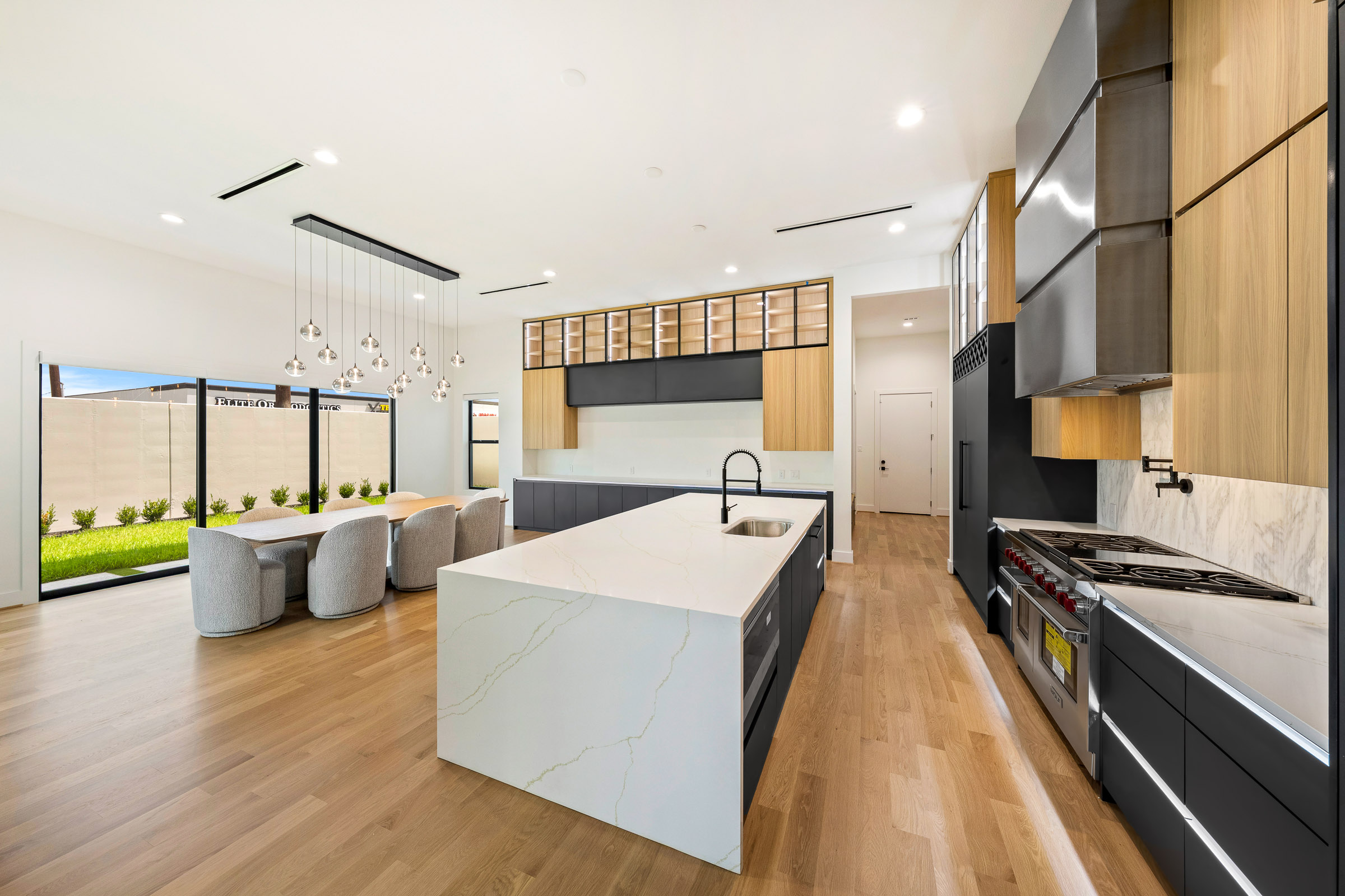 Dining area with glass table, stone fireplace and garden views
