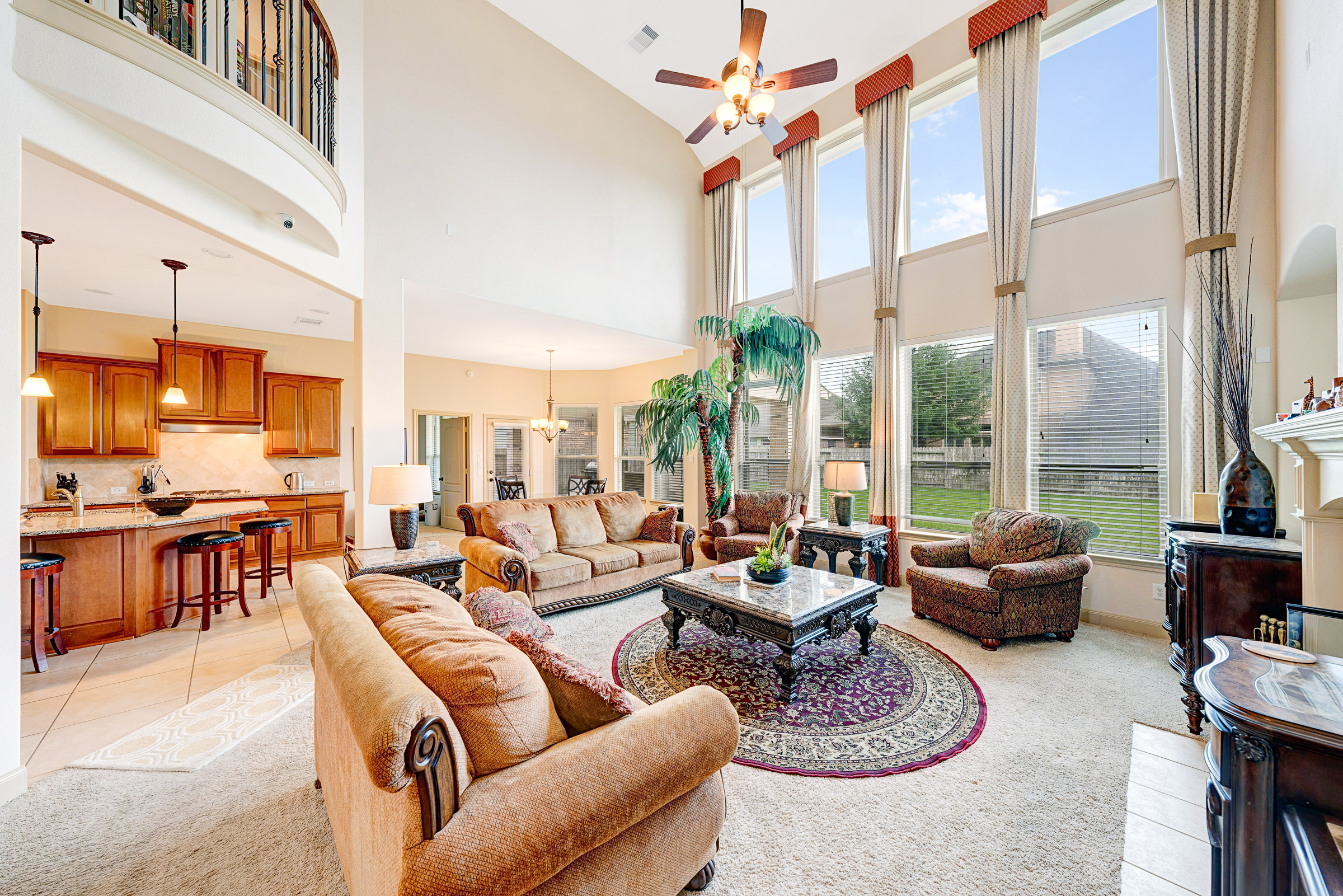 Two-story living room with soaring windows and open kitchen